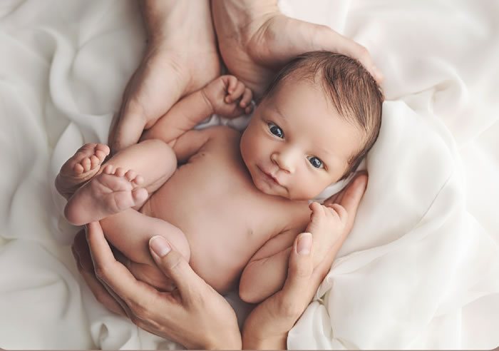 bébé entre mains parents